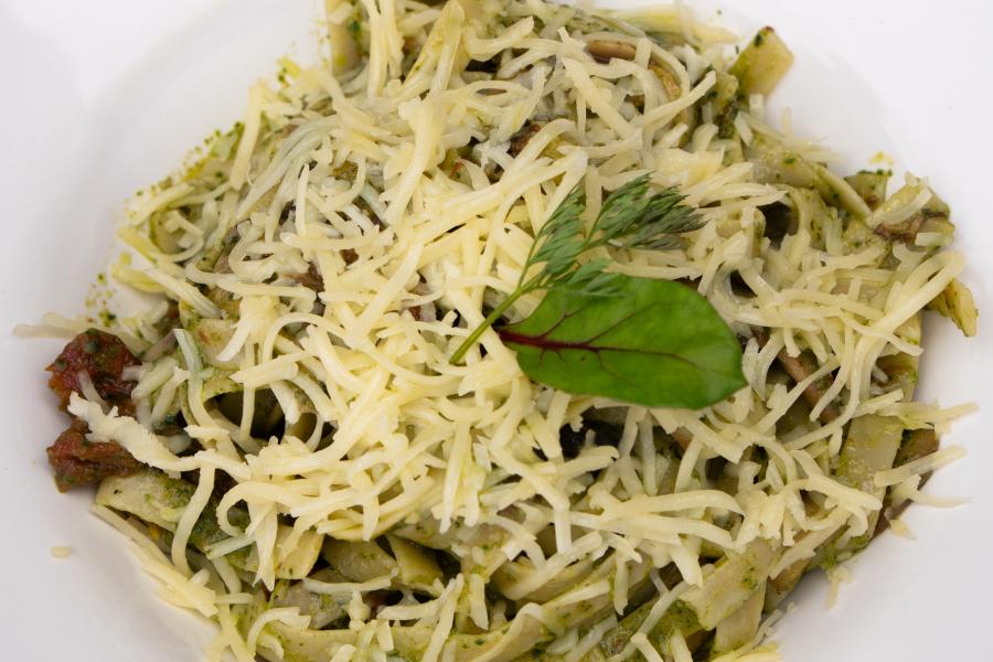 Fettuccine pestos, albahaca fresca pepa de zambo tomates confitados, acompañado de queso parmesano