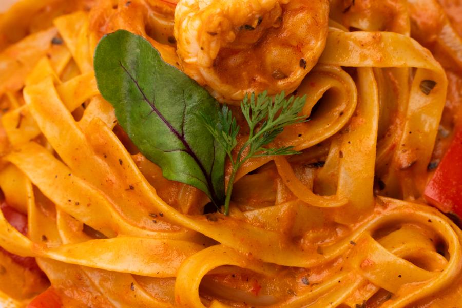 Fettuccine de camarón, con salsa napolitana y crema de leche, camarones perfumados con limón y especies.