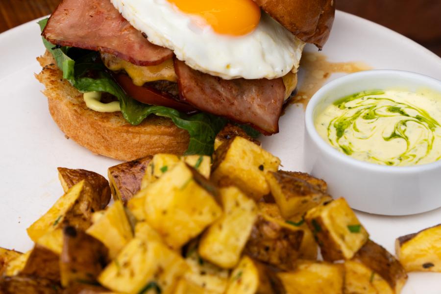 Criolla burguer, hamburguesa con queso chedar, tocino, huevo, papas salteadas con mantequilla y perejil, acompañadas con nuestra mayonesa especial de la casa.