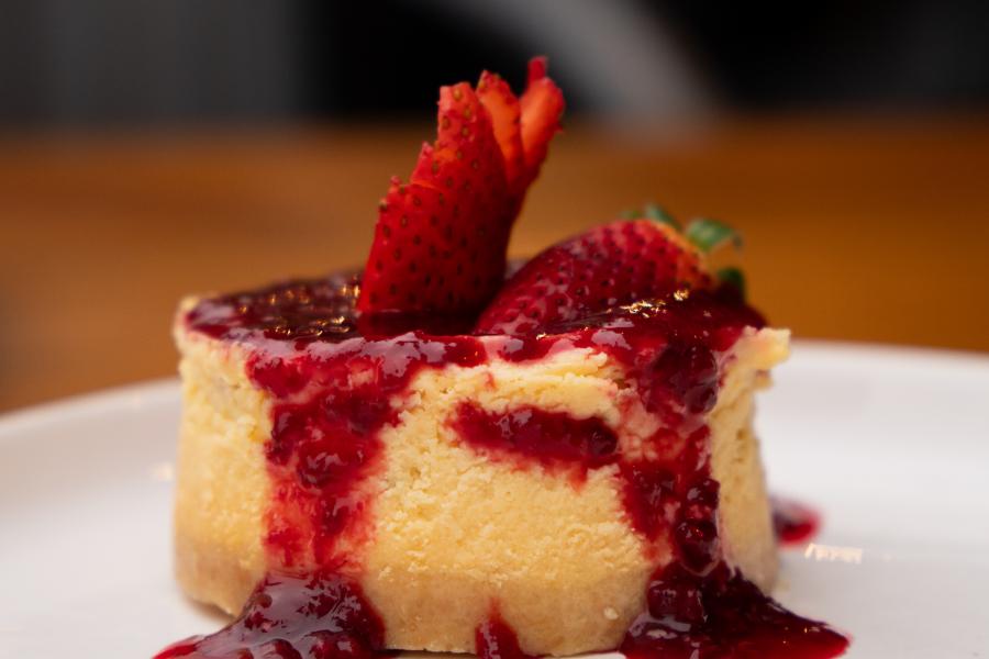 Cheesecake de frutos rojos, cheesecake fusión de newyork y vasco, cremoso y coronado con una compota casera de fresas y moras, con una fresa organica fresca